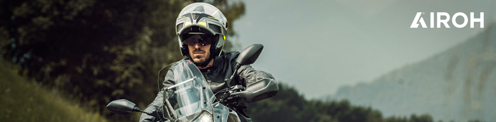 Airoh Helme - Mann auf Motorrad vor Bergen mit Airoh Commander Helm